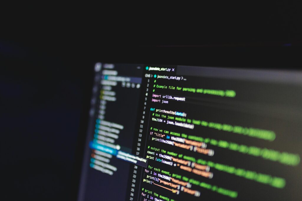 Programming code on a computer screen in a dark room, showcasing technology and IT expertise.